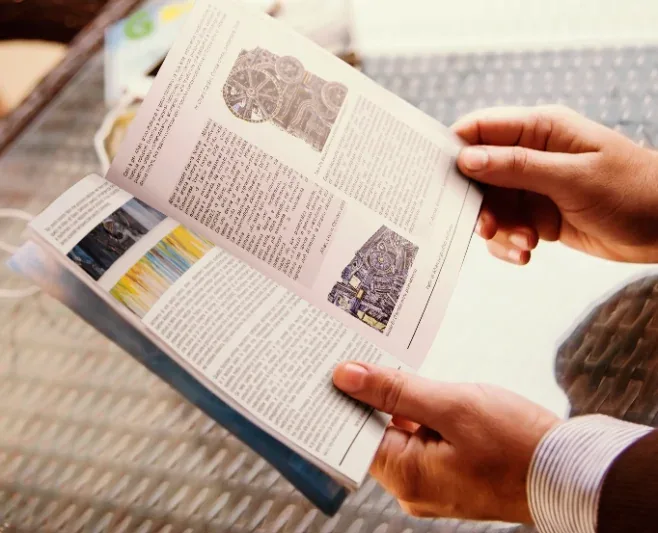 Mani che sfogliano una rivista con il servizio editoriale realizzato per Afran
